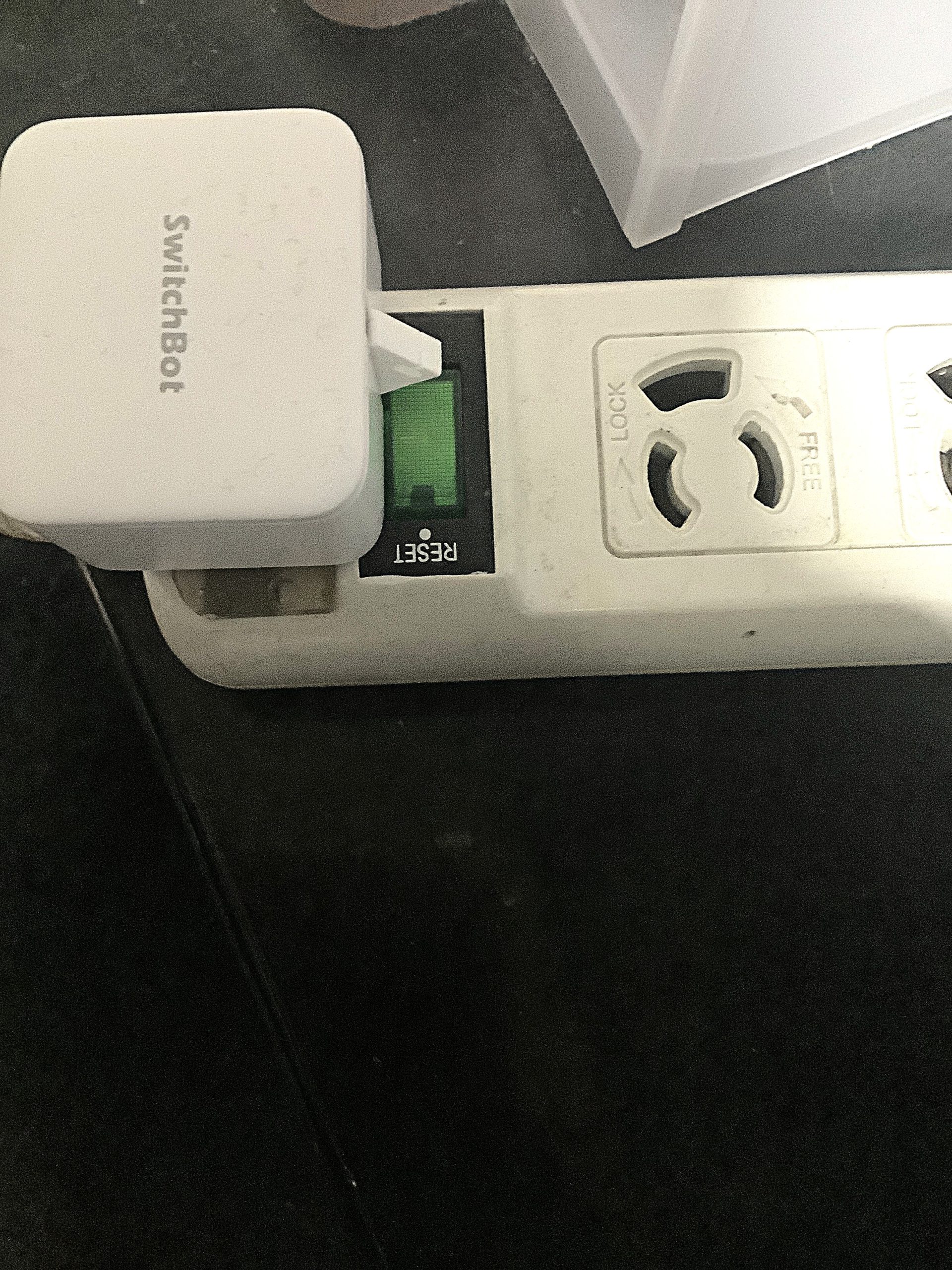 延長コードのスイッチ部分にSwitchBot Botを取り付けた状態。